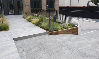 Chic driveway with Argent Block Paving Dark, beside porcelain pathway.