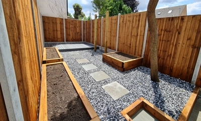 Backyard serenity: 6-foot Close Board fence, wooden planters, and stylish stones.