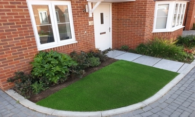Inviting entrance with lush artificial lawn, enhancing curb appeal effortlessly.