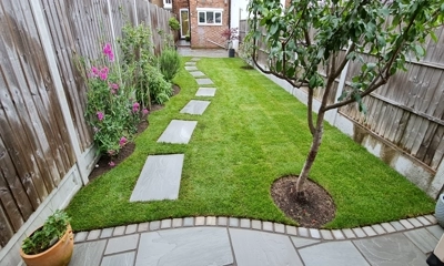 Fresh turf rolls adorned with Kandla gray stepping stones creates inviting tranquility.