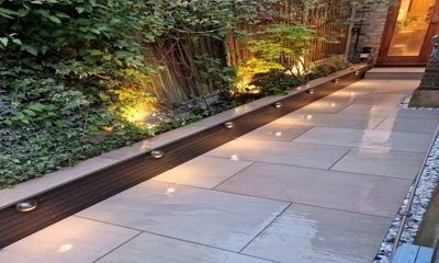 Raj Green porcelain, framed by composite battens, thrives in wall planter.