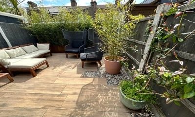 Randomly installed wooden porcelain planks with a pebble shingle border.