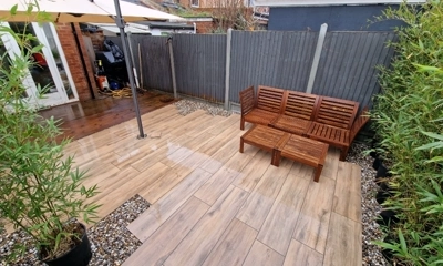 Wooden porcelain planks with pebble shingle border, artfully arranged in randomness.