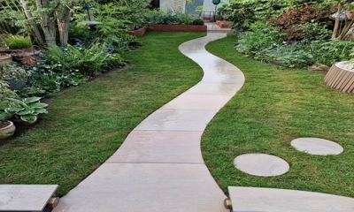 "Graceful Raj Green porcelain snake path through lush new lawn."