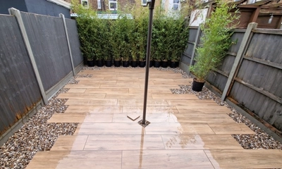 Natural wood-finish porcelain planks complemented by pebble shingle border.