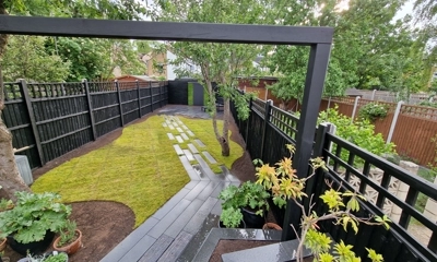 Granite plank stepping stones create an artful path through backyard turf. Back garden design in London 