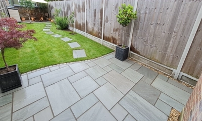 Elegant Kandla gray patio designed with varied sizes sandstone in French pattern."