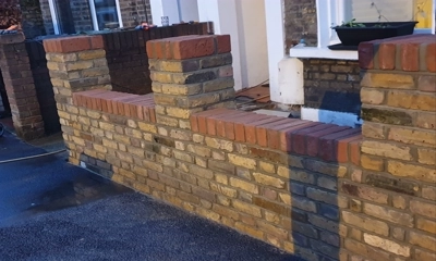 Vintage charm with yellow stock brick wall with a red brick top in the front garden 
