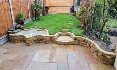 Curved reclaimed brick wall adds charm and structure to the landscape.