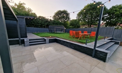 Retaining wall adorned in Imperial Black Slate Cladding, complemented by silver grey granite steps and coping-stones.