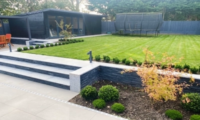 Flat flower bed beside Victorian granite steps, porcelain paving, and 3D cladding.