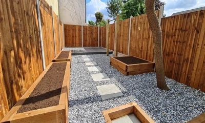 Wooden planters with black ice stones, enhancing garden elegance beautifully.