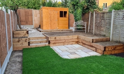 Wood sleeper retaining walls and planters enhancing outdoor landscaping charm.