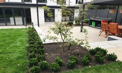 Flat planters embraced by granite edges, nestled in lush green turf