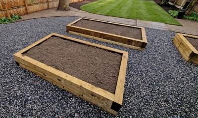 Wooden raised beds adorned with decorative stones, creating an inviting garden.